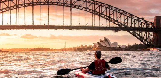 Homem navegando em um bote no mar de Sydney