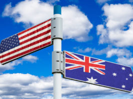 Placa apontando para direções diferentes com as bandeiras dos Estados Unidos e da Austrália em cada placa.