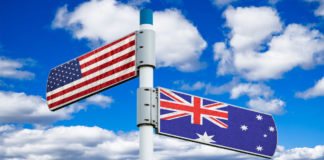 Placa apontando para direções diferentes com as bandeiras dos Estados Unidos e da Austrália em cada placa.