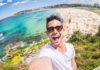 homem tirando selfie em frente a uma praia