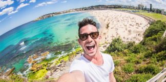 homem tirando selfie em frente a uma praia