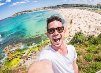 homem tirando selfie em frente a uma praia