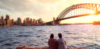 casal sentado em frente à ponte harbour bridge