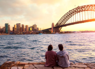 casal sentado em frente à ponte harbour bridge