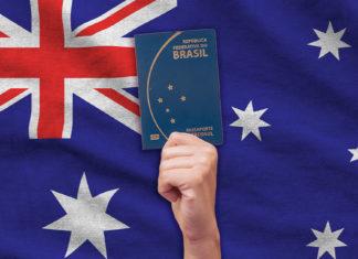 passaporte brasileiro em frente a uma bandeira da australia